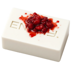 White dessert with red fruit topping on a white background