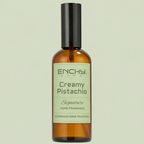 Brown bottle of Enchy Creamy Pistachio home fragrance on a light green background